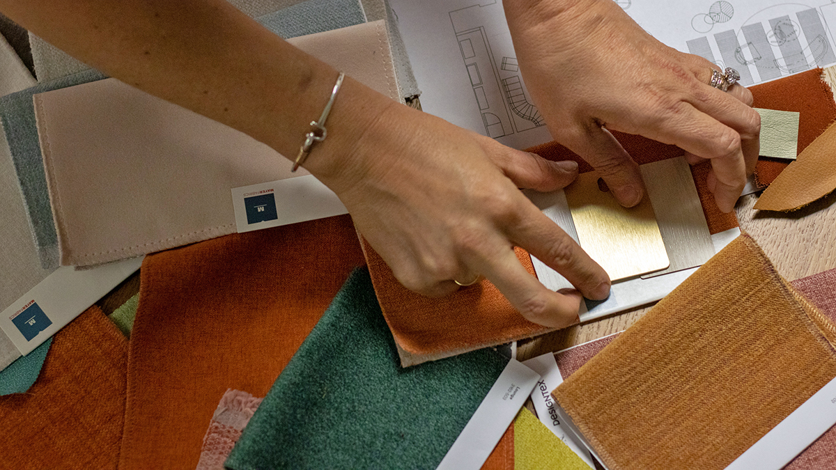 hands arranging material lay for interior design at bowling center